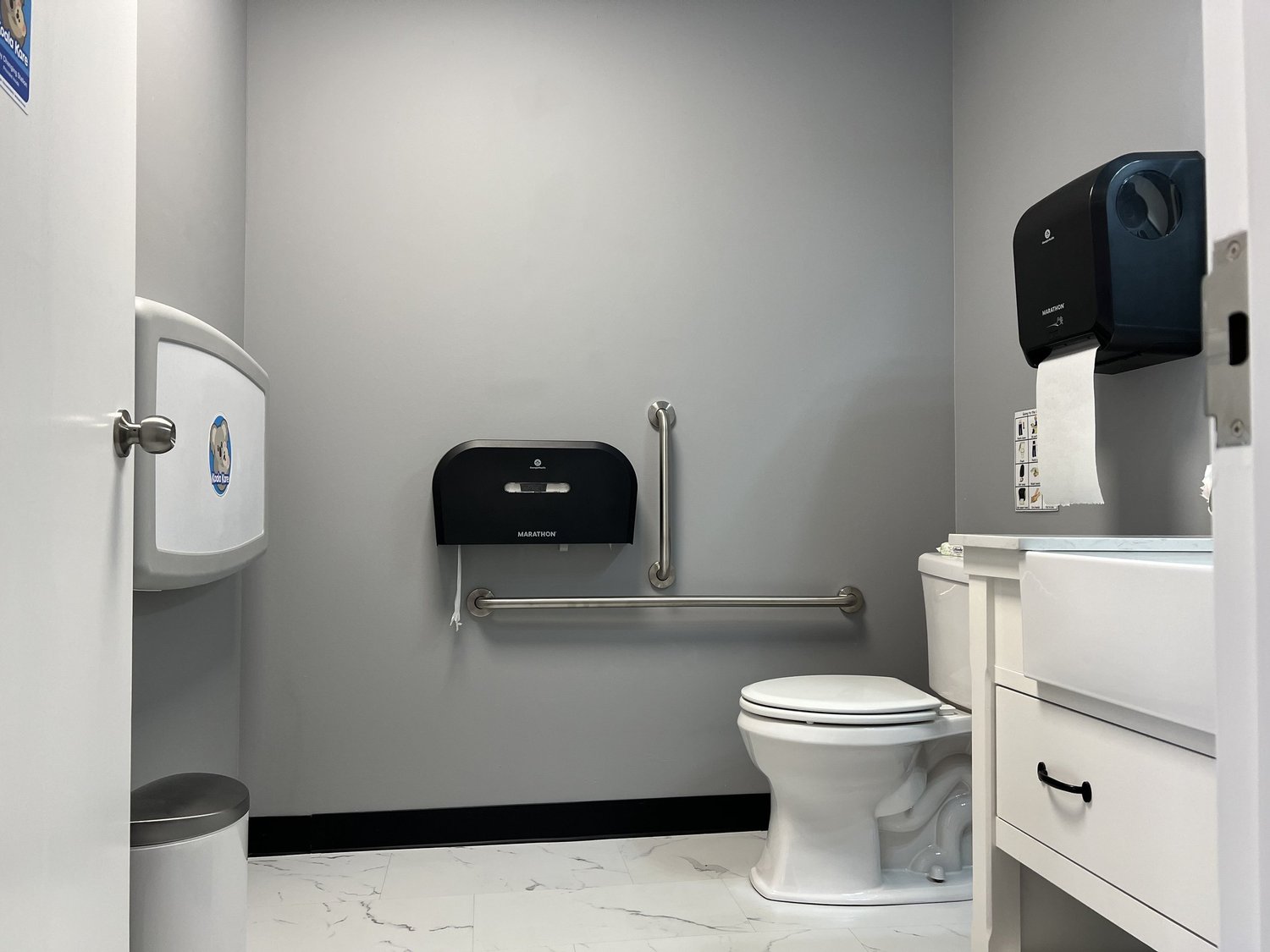 Handicapped Accessible Bathroom with changing table, child seat, and child stool 